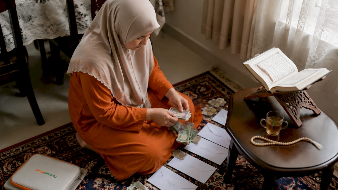 Woman preparing Ramadan charity envelopes